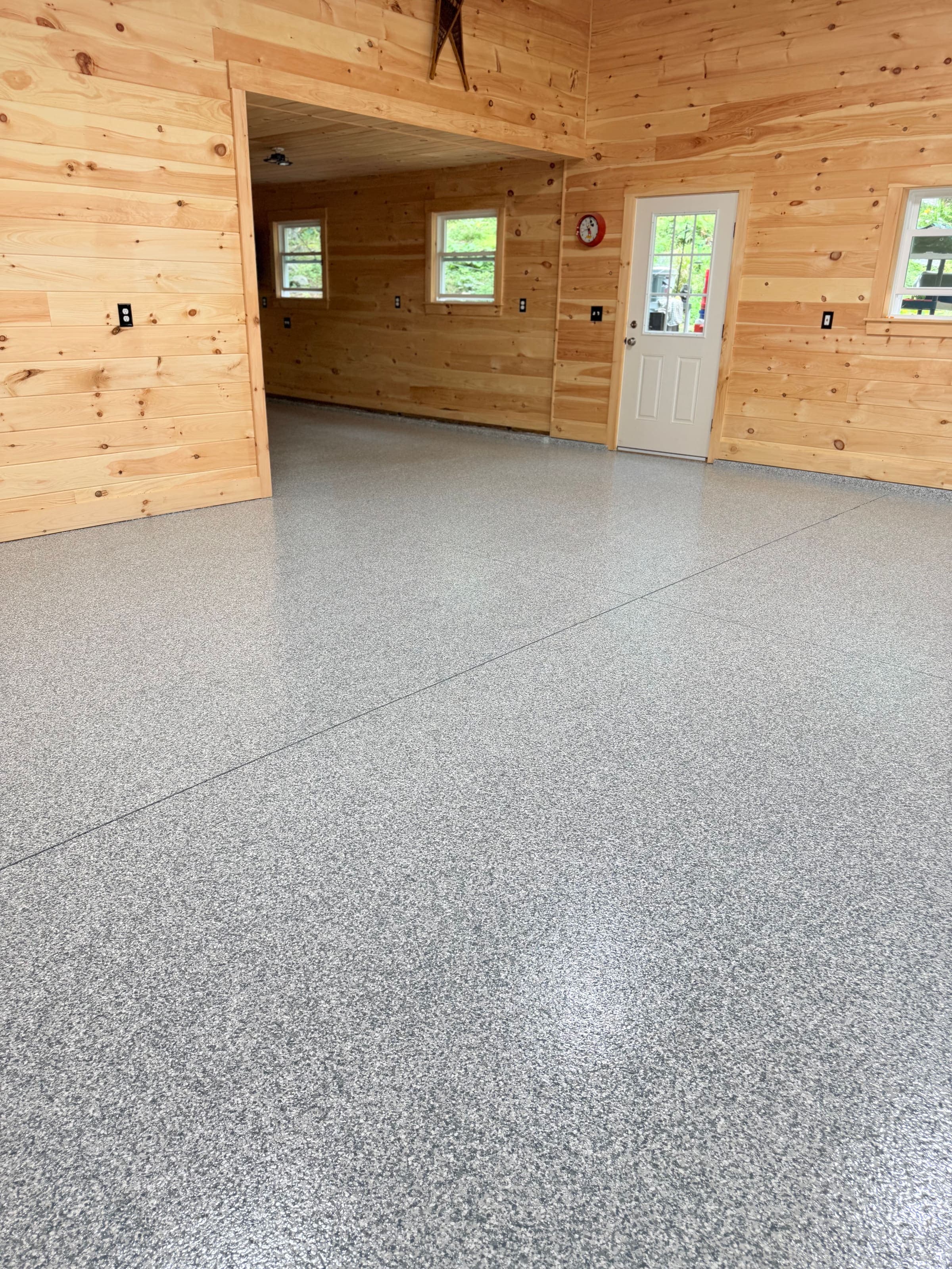 Lakeside camp garage with pine walls and gray flake epoxy floor