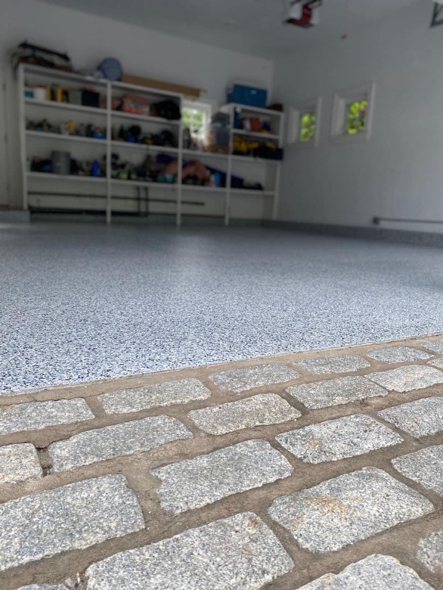 Flake floor meeting a cobblestone apron