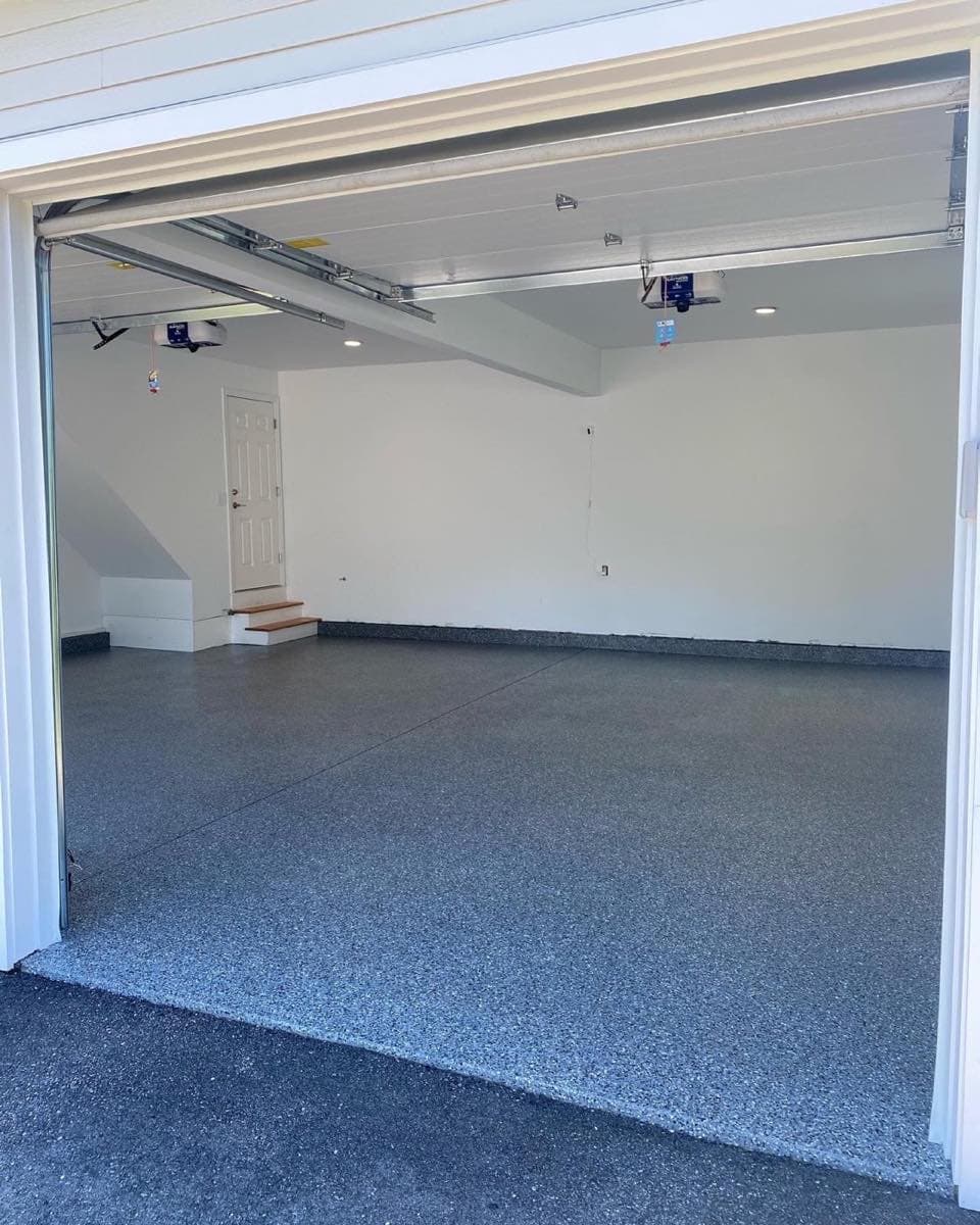 Flake epoxy garage floor in a lit bay, freshly finished