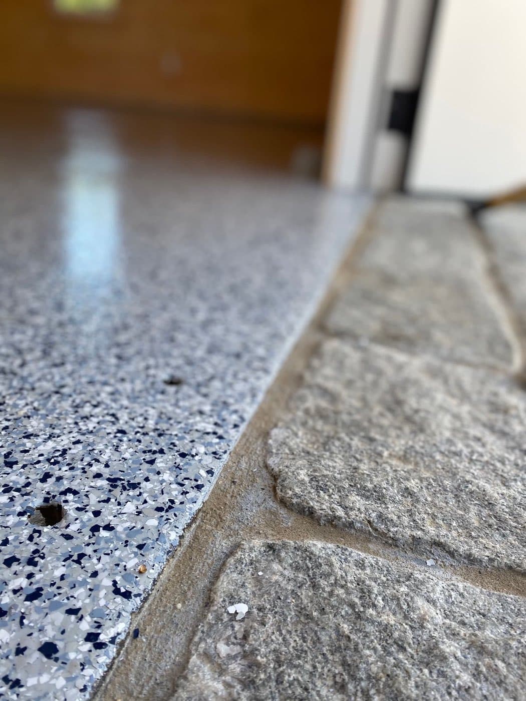 Flake epoxy floor meeting a granite ledge