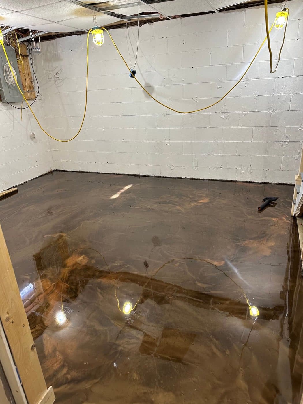 Metallic epoxy floor being poured and worked by hand